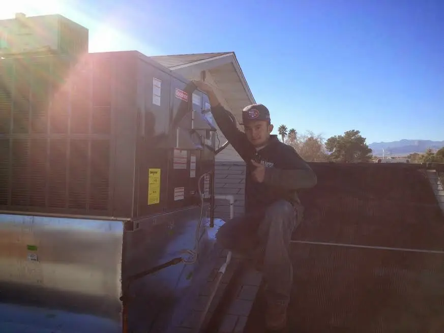 HVAC technician performing Heat Pump Repair on a rooftop unit in Patchogue
